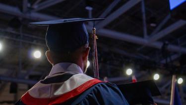 2023 Graduate Back of the head of a graduate as they look out into the audience