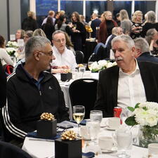Two attendees sitting at table talking
