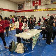 Gym filled with students who are checking out information tables about clubs at the school